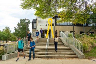 ALLENDALE, MI, USA, SEPTEMBER 20, 2024: Unidentified individuals and Mackinac Hall on the campus of Grand Valley State University. clipart