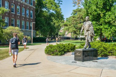 EAST LANSING, MI, USA, SEPTEMBER 19, 2024: Unidentified individuals and John A. Hanna Sculpture on the campus of Michigan State University. clipart