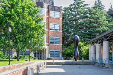 SEATTLE, WA, ABD, 25 Mayıs 2025: Washington Üniversitesi kampüsündeki Red Pin Heykeli ve Bagley Salonu.