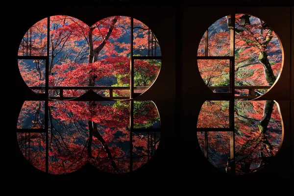 Japanese autumn scenery view through round windows reflected on a table