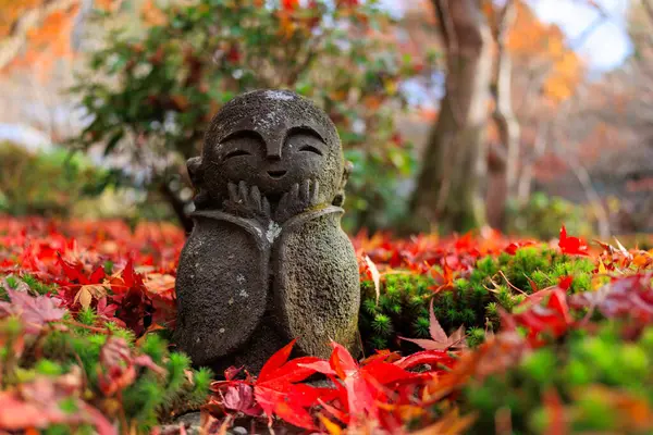 Jizo Staty Med Ett Leende Ansikte Sitter Hög Med Röda Royaltyfria Stockbilder
