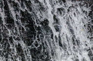 Bir kayanın üzerinde akan suyun soyut fotoğrafı, yüksek deklanşör hızı