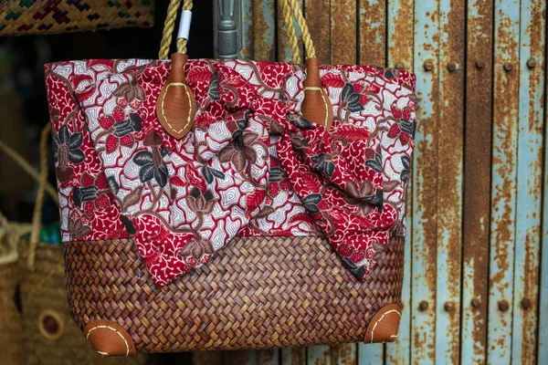Weave rattan woman shoulder bag  with red ribbon to sell in vintage store at Chanthaburi old building village, Thailand.
