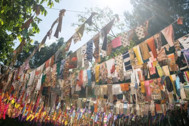 Thai traidtional nrothen east style painting fabric hanging on rope attached on trees. Colorful pattern cloth.