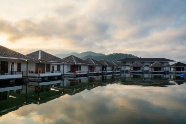 floating homestay resort with skyline reflection on lake at sunrise in Srinakarin or Srinagarind Dam, Kanchanaburi, Thailand. Famous travel at summer in tropical country, Siam.