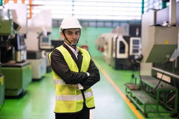Portrait of young factory Asian manager with hardhat at microchip semiconductor machine. manufacturing industry.