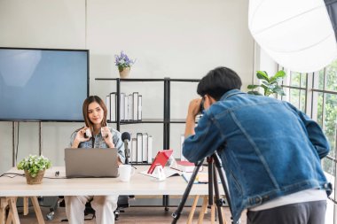 Behind the scene concept. Videographer shoot young Asian female blogger to record streaming live online with studio lighting. broadcasting vlogger. internet influencer.
