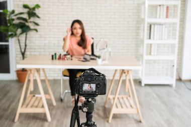 Behind the scene concept. Recording beauty blogger show brushing eyelash to audiences recorded by dslr camera. Live record to broadcast online. Focus at digital camera.