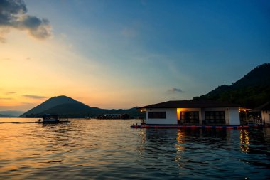 Srinakarin 'de ya da Srinagarind Barajı' nda, Kanchanabur 'da, Tayland' da gün batımında yüzen ev tatil beldesinde. Yaz mevsiminde tropikal ülkede ünlü seyahat, Siyam.