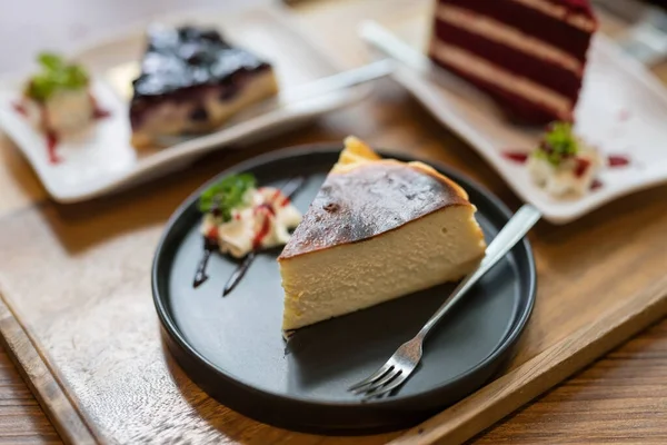ブルーベリーチーズケーキのブルーベリーチーズケーキとテキストのコピースペースのあるカフェレストランの木製テーブルの上の赤いベルベットとおいしいチーズケーキ 甘いデザート — ストック写真