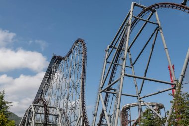 Fuji-Q Highland, Yamanashi, Japonya 'da mavi gökyüzüne karşı hız treni.
