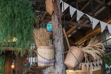 Kuru çiçek buketi ve pilav bambu sepeti içinde. Restoranın içindeki ahşap sütun süslenmiş..