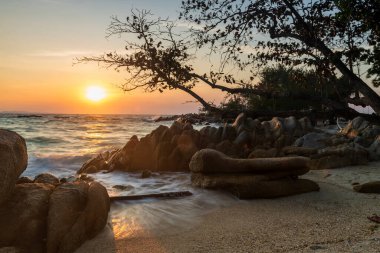 motion wave seascape through stone arch at sunrise in Ko Man Klang, Rayong, Thailand. Famous travel destination and summer holiday vacation in tropical country, Siam.