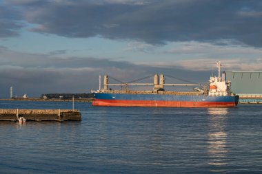 Shizuoka, Japonya, Shimizu limanından büyük bir kargo gemisi gün batımında yola çıkıyor. Lojistik endüstrisi