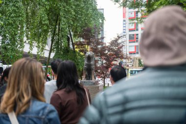 Tokyo, Japonya 'daki Shibuya istasyonunun önündeki Hachiko köpek heykelini turistler ziyaret ediyor..