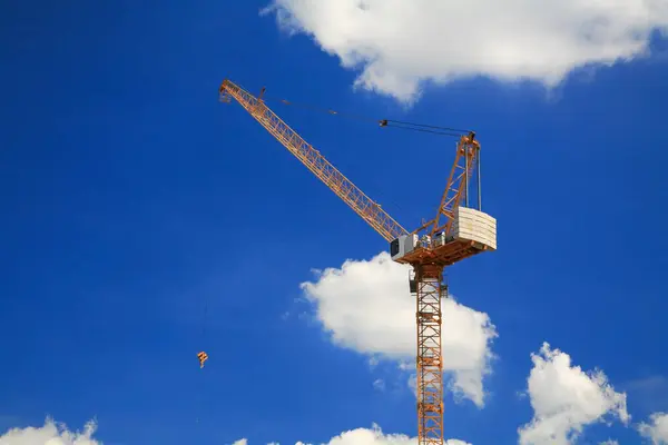 Żółty Żuraw Wieżowy Buduje Wieżowiec Przeciwko Błękitnemu Niebu Białej Chmurze — Zdjęcie stockowe