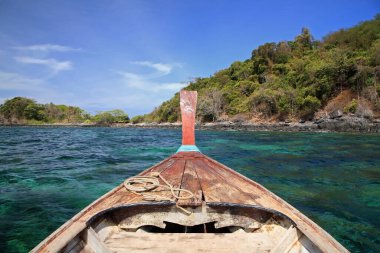 Mavi gökyüzüne, Satun, Tayland 'daki Ko Lipe adasına karşı şnorkelle yüzmek için turkuaz Andaman' da yelken açan ahşap tekne. Ünlü seyahat merkezi ya da tropikal ülkede tatilci, Siyam.