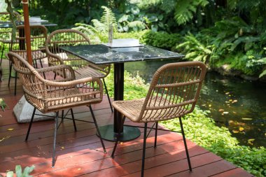 Tropikal kafe ve restoranın bahar ağacı dekorasyonuyla birlikte göletin yanında açık hava terası..