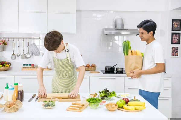 Cute Asian boyfriend surprise his partner during making sandwich for breakfast. He buy bread and vegetable to his sweet. LGBT gay couple. Homosexual same sex family with healthy eat lifestyle.