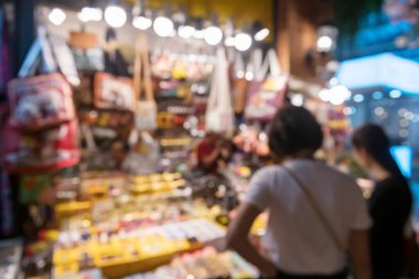 Asyatik 'ten alışveriş yapan insanların soyut bulanık görüntüsü. Tayland, Bangkok' ta gece nehir kıyısında. Siyam 'da ünlü bir tatil beldesi.