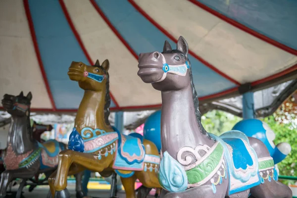 遊園地に3頭のメリーゴーラウンド馬 楽しいフェアのカルーセル — ストック写真