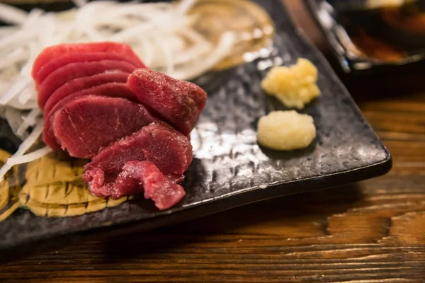 日本餐馆的马尾肉生鱼片配以芥末 木桌等配餐 — 图库照片