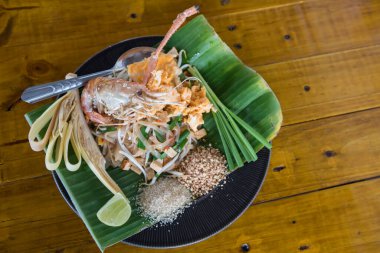 Büyük karides ve çeşit çeşit sebzeli Tayland eriştesi. En tepeden bakıldığında ünlü Tayland yemekleri.