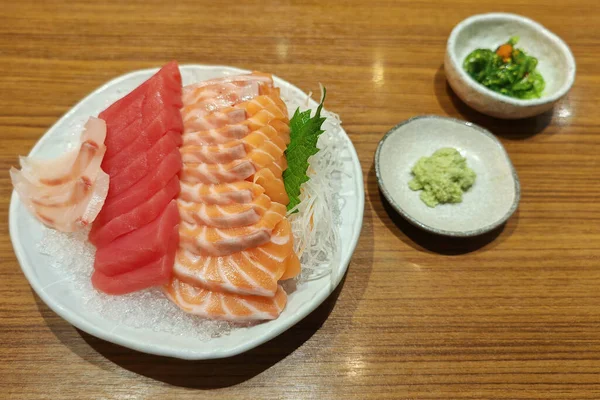 日本餐馆木桌上的新鲜鲑鱼 金枪鱼或马古罗 冰块上的红金鱼 芥末和海藻 — 图库照片
