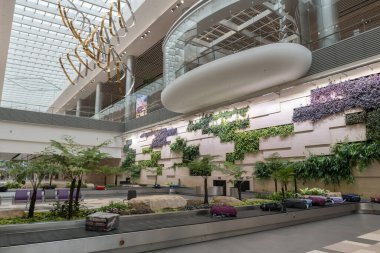 Changi Havaalanı 'ndaki 4 numaralı terminalin iç kısımlarında valiz konveyör bandında. Burası Güneydoğu Asya 'nın en işlek yolcu merkezlerinden biri..