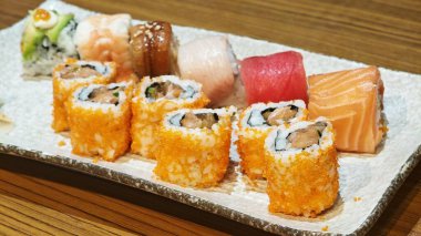 Suşi ebi dürümleri Japon restoranındaki ahşap masaya dizildi. Ünlü geleneksel Japon yemekleri..