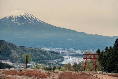 Kawaguchi Asama Tapınağı kırmızı torii kapısı ve Fuji Dağı alacakaranlıkta, Yamanashi, Japonya. Kawaguchikon Gölü çevresindeki ünlü seyahat merkezinin manzarası.