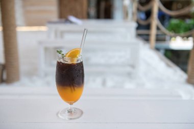 Americano yuzu sütsüz buzlu kahve. Modern kafe ve restoranın beyaz masasında taze portakallı. Yiyecek ve içecek endüstrisi.