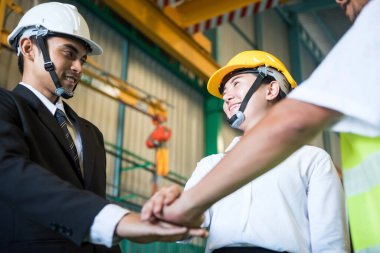 Sinerji ve takım çalışması konsepti ağır sanayi ya da gülen yüzlü depo işini başarıya ulaştırır. El işi ve fabrika işçilerinin birbirine bakması..