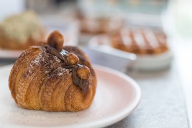 Çikolatalı kruvasan, kafeteryada ve restoranda yemeklerde bulanık kek ve macadamia..
