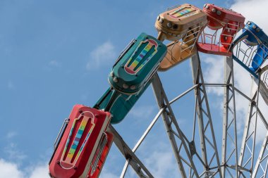 Yazın lunaparkta mavi gökyüzüne karşı dönme dolap girdabı.