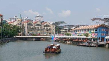 Sabah Singapur nehri üzerinden Clarke Quay ve Riverside Point 'i ziyarete giden turist gemisi. Bölge, barları ve restoranları ile ünlüdür.