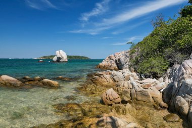 Turkuaz deniz üzerinde doğal taştan kemerli güzel bir deniz manzarası ayrı denizde mavi gökyüzüne karşı, Thale Waek, Ko Man Klang, Rayong, Tayland.
