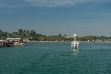 Mavi gökyüzüne, Rayong 'a, Tayland' a karşı Ko Man Nok 'a nakledilecek Makampom rıhtımındaki beyaz deniz feneri..