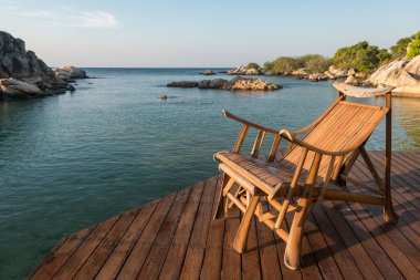 Tatil köyünün verandasında sabah taş kemerli tahta koltuk, Ko Man Klang, Rayong, Tayland. Meşhur seyahat yeri ve Siam 'da yaz tatili