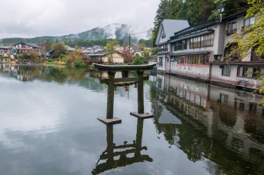 İlkbaharda Kinrin Gölü 'ndeki Antik Torii Kapısı Yufu Dağı' nın manzaralı yerinde. Oita Bölgesi, Kyushu, Japonya 'daki ünlü tatil beldesi Yufuin' in.