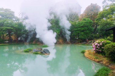 Shiraike jigoku white pond hell with heavy steam and reflection at spring, Beppu, Oita, Kyushu, Japan. Town is famous for its onsen hot springs and 8 major geothermal hot spots, 8 hells of Beppu. clipart