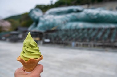 Nanzoin Tapınağı, Fukuoka, Kyushu, Japonya 'da uzanan bulanık Buda heykelli yeşil çay dondurması. Ünlü seyahat merkezinde tatlı bir tatlı..