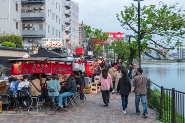 Fukuoka, Japonya - 7 Nisan 2024: Yatai gıda tezgahları Kanal şehri Hakata yakınlarındaki Naka nehri boyunca. Fukuoka 'daki en iyi sokak yemeği için ünlü bir yer.