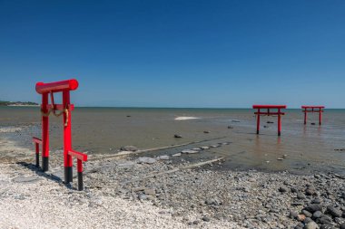 Japonya 'daki Tara Town, Saga, Kyushu' daki Oouo Tapınağı 'nda Ariake Denizi' ndeki üç kırmızı torii kapısının mavi gökyüzüne karşı görüntüsü. Meşhur seyahat yeri. Japonca Okino İngilizcede açık deniz ya da açık deniz anlamına gelir.