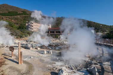 Shimabara, Nagasaki, Kyushu, Japonya 'daki Mount Unzen onsen Kaplıcaları' ndaki Ryokan oteli ile Jigoku Vadisi girişi. Sıcak su, sülfür gazı ve ısınmış volkanik kaynak tarlasından fışkıran buhar..