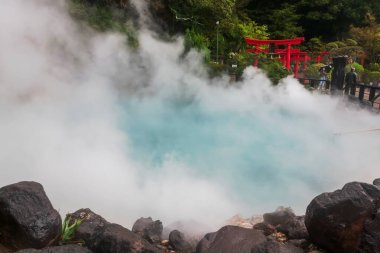 Umi Jigoku Denizi Cehennemi veya kırmızı torii kapılı kobalt mavisi gölet ve ağır buharlı Kamado Jigoku, Beppu, Oita, Japonya. Seyahat yeri ve sekiz cehennemin en ünlü fotoğrafçılarından biri..