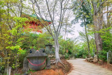 Nyoirinji Tapınağı, Ogori, Fukuoka, Japonya 'daki kırmızı pagoda' nın önündeki kurbağa taşı heykeli. Burası Kaeru Dera olarak bilinen kurbağa heykeliyle ünlü, resmi adı ise Seieizan Nyoirin-ji..