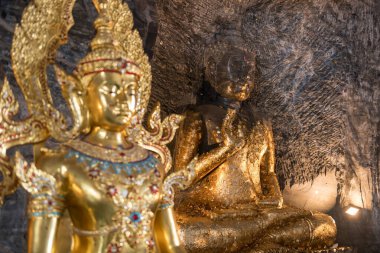 Antik taş Buda heykeli ve dağ mağarası tüneli Wat Khao Tham Thiam, Suphan Buri, Tayland 'da altın tanrı. Siyam 'da ünlü bir tatil beldesi.