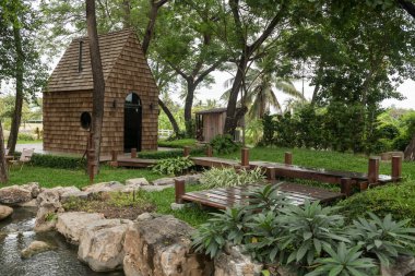 Bahar Parkı 'ndaki göl kenarındaki ahşap kulübe ve bahçe. Cafe ve restoran, açık sandalye ve masa..