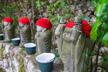 Şirin Buda heykeli, bahar mevsiminde Nanzoin Tapınağı 'nda kırmızı kazakla el kaldırıyor Sasaguri, Fukuoka, Kyushu, Japonya. En büyük uzanan Buda heykelini ziyaret etmek için ünlü seyahat yeri..